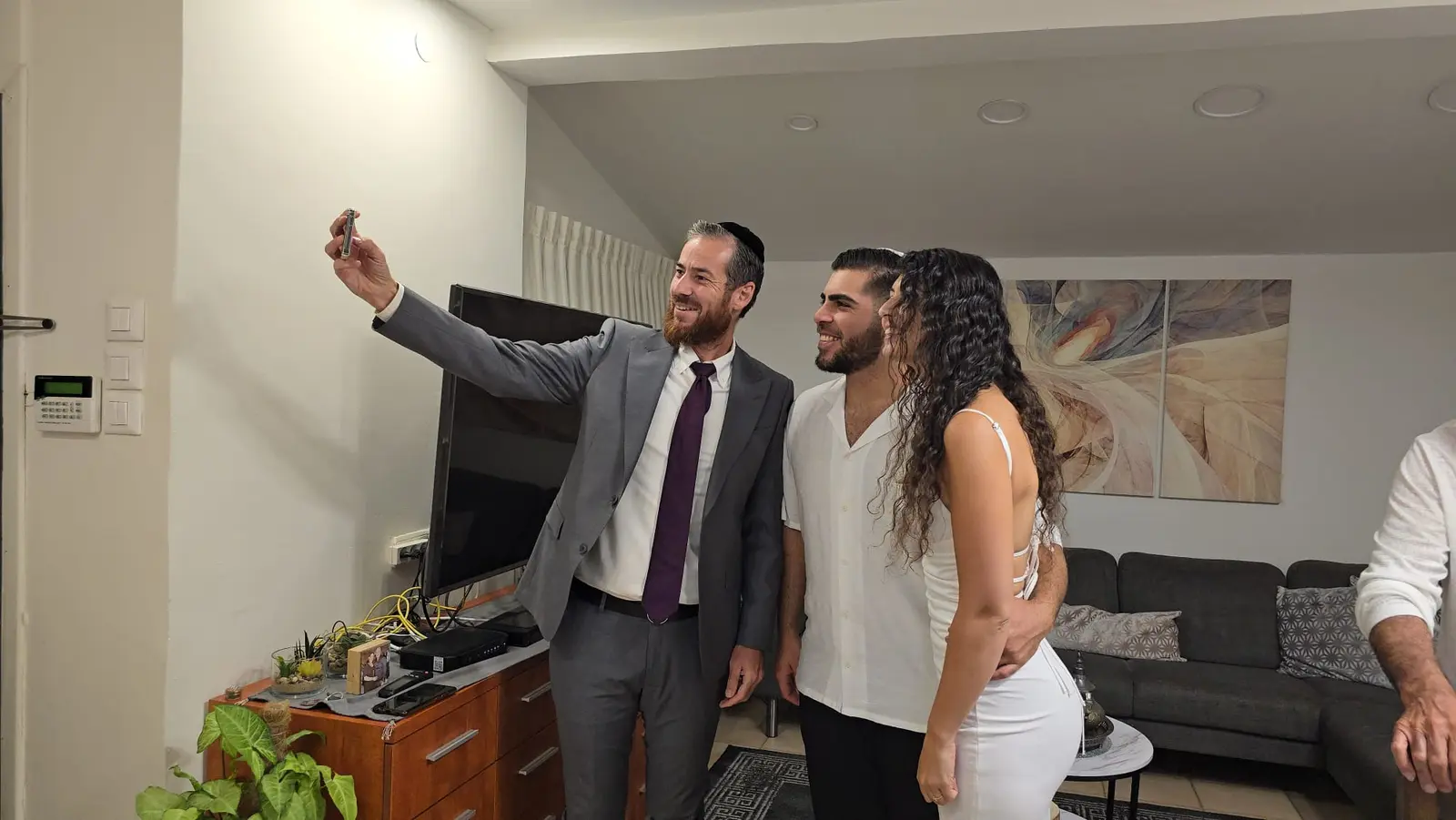 הרב דוד והזוג מחייכים ברגע אישי בטקס